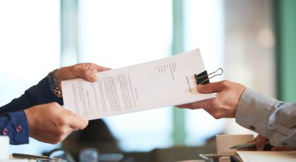 Business person giving partnership agreement to coworker